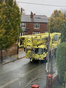 A crane makes its way down a residential street ready for construction of the new modular building.