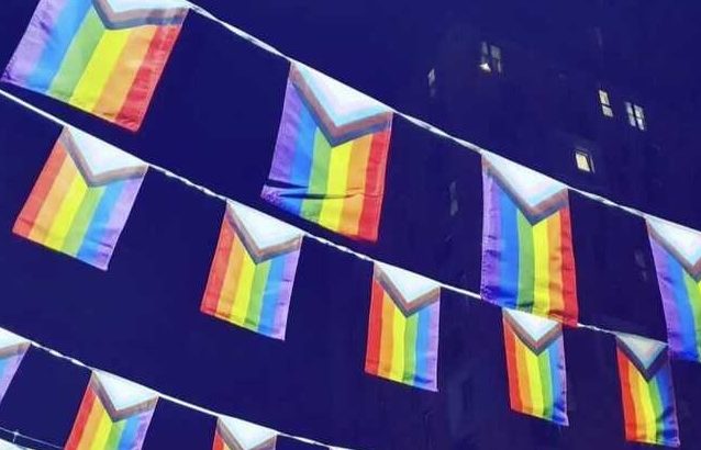 How to avoid rainbow washing in your Pride month campaign: picture is of the rainbow Pride event flags strung above the street in Manchester