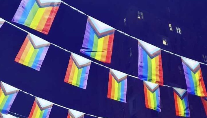 How to avoid rainbow washing in your Pride month campaign: picture is of the rainbow Pride event flags strung above the street in Manchester